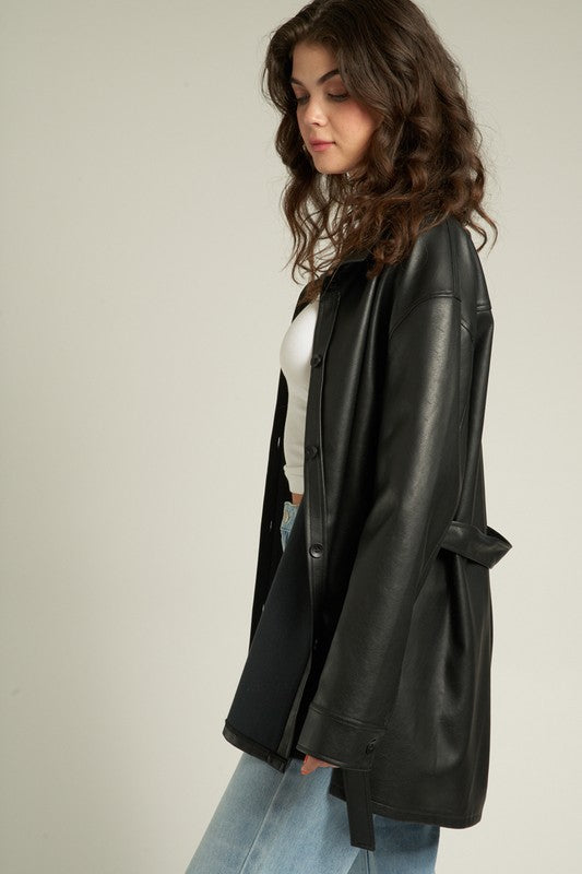 Woman in a Lyra Faux Leather Jacket styled with a cinched waist, showcasing a trendy and relaxed silhouette.