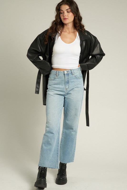 Model wearing the Lyra Faux Leather Jacket over a white top and light jeans, showcasing its stylish design.