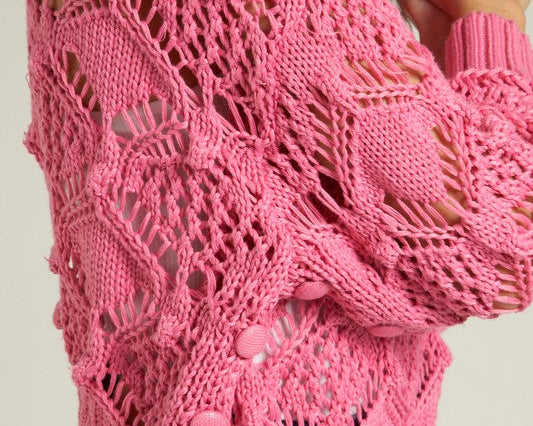 A stylish pink knit sweater showcasing intricate patterns, perfect for winter to spring styling.