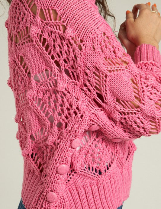 A stylish pink knit sweater showcasing intricate patterns, perfect for winter to spring styling.