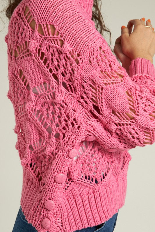 A stylish pink knit sweater showcasing intricate patterns, perfect for winter to spring styling.