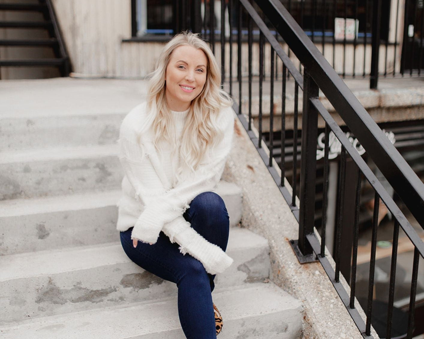 A woman sitting on stairs in casual fashion, explaining why I started a style bar, looking stylish and confident.
