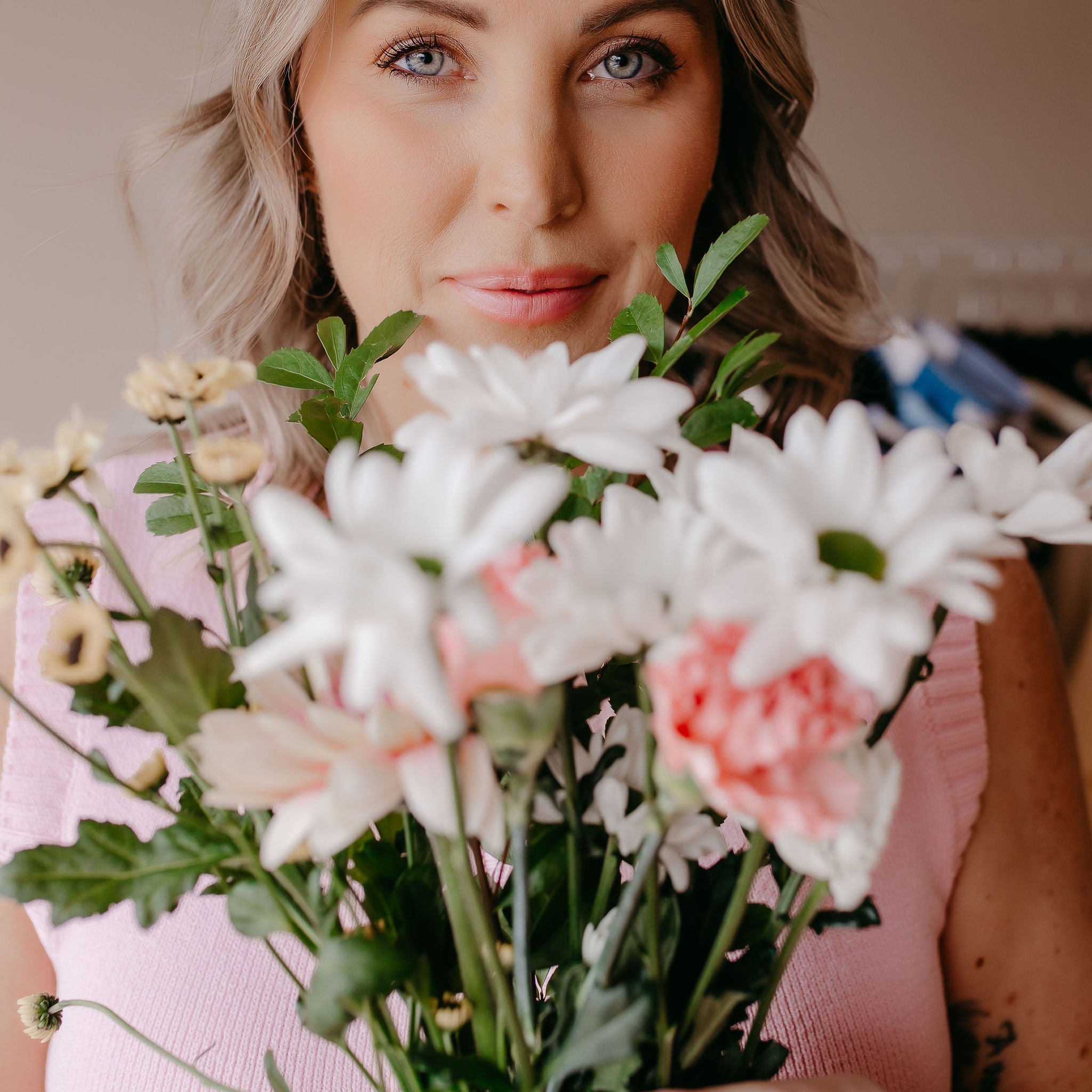 Woman holding a bouquet of flowers, celebrating the Mothers Day collection with thoughtful gifts for women.