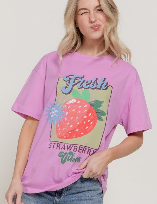 Young woman wearing a Sweet Patch Graphic Tee with strawberry design, featuring a playful graphic and relaxed fit.