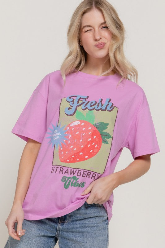 Young woman wearing a Sweet Patch Graphic Tee with strawberry design, featuring a playful graphic and relaxed fit.
