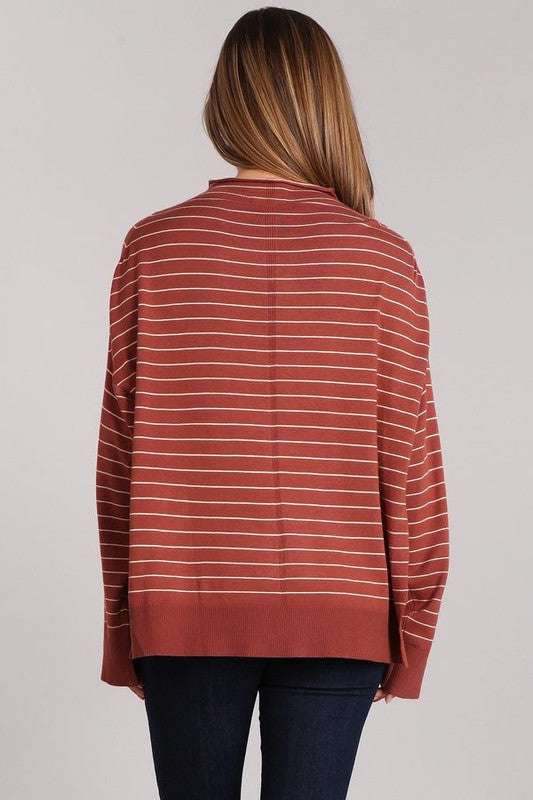 Back view of the Aubrey Knit Pullover in a rust striped design, showcasing its oversized fit and hi-low hem.