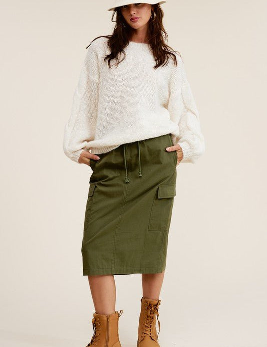 Ulla Cargo Pocket SkirtCombine the details of your favorite cargo pants with the sophisticated silhouette of a midi skirt with this stunning piece. It features a mid-rise, elasticated waistband with drawstring, and a slit at the back for added comfort and