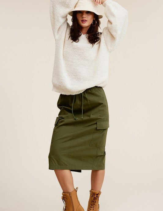 Ulla Cargo Pocket SkirtCombine the details of your favorite cargo pants with the sophisticated silhouette of a midi skirt with this stunning piece. It features a mid-rise, elasticated waistband with drawstring, and a slit at the back for added comfort and